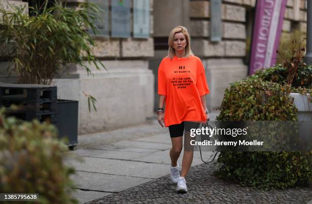 Palina Kozyrava is wearing Balenciaga black mini basket bag, Balenciaga neon orange statement shirt, black shorts and File white sneaker on March 15,...