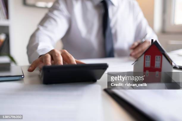 business man using calculator with computer laptop, budget and loan paper in office. - real estate auction stock pictures, royalty-free photos & images