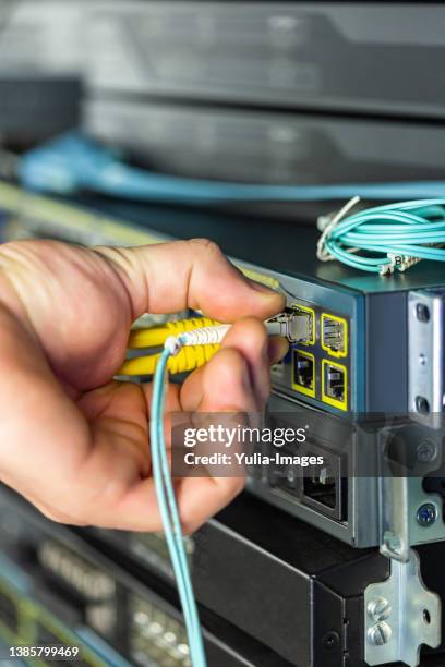 engineer ot technician withdrawing a lan or ethernet cable - computer cable foto e immagini stock