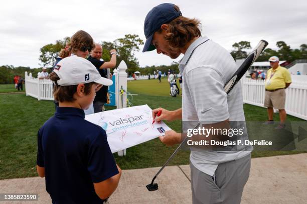 Tommy Fleetwood of England signs an autograph on the practice green during the Tampa General Hospital Championship Pro-Am prior to the Valspar...