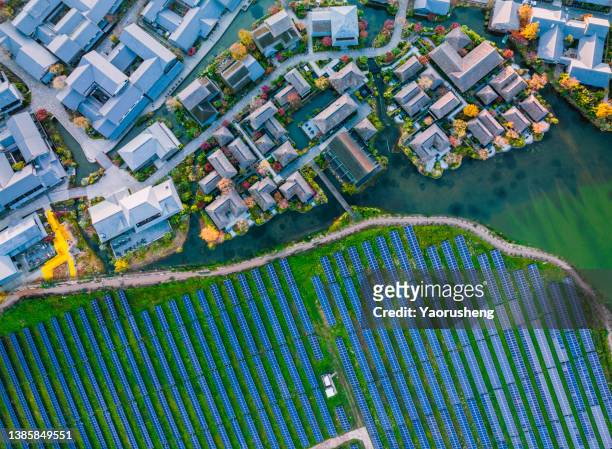 solar power station with modern city buildings - aereal view stock-fotos und bilder