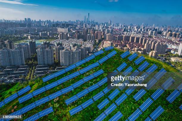 solar power station with modern city buildings - solar panel city stock-fotos und bilder
