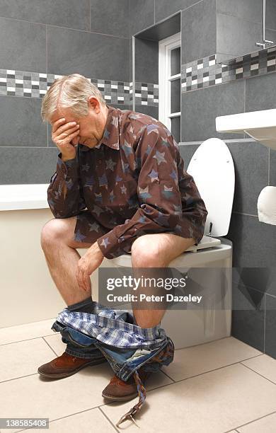 mature man suffers from piles - hombre baño fotografías e imágenes de stock