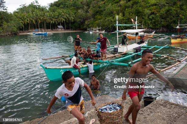 fishermen offload their catch in sipalay, negros occidental, philippines. - negros occidental stock pictures, royalty-free photos & images