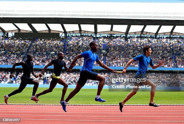 relay race, male athletes passing relay baton - mens track stock pictures, royalty-free photos & images