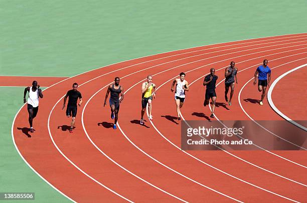 runners racing on track - leichtathletik stock-fotos und bilder