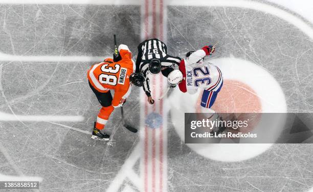 Linesman Kory Nagy prepares to drop the puck on a face-off between Patrick Brown of the Philadelphia Flyers and Rem Pitlick of the Montreal Canadiens...