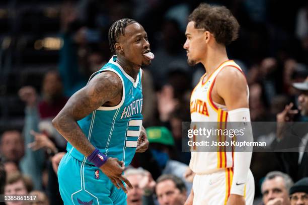 Terry Rozier of the Charlotte Hornets reacts after making a 3-point shot while Trae Young of the Atlanta Hawks looks on in the fourth quarter during...
