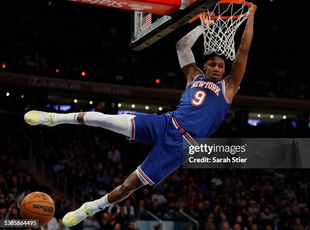 Barrett of the New York Knicks hangs on the basket after dunking during the second half against the Portland Trail Blazers at Madison Square Garden...