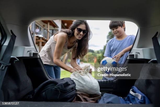 mother picking up her son from soccer practice in her car - kids practicing stock pictures, royalty-free photos & images