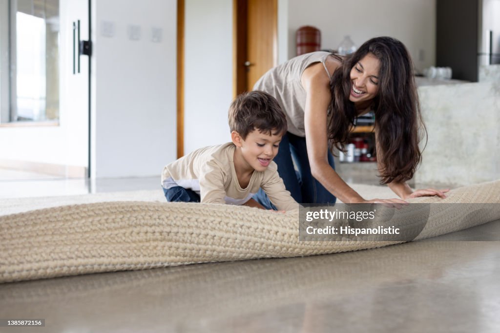 Unroll Boy Helping His Mother Unroll A Carpet At Home High-Res Stock Photo ...