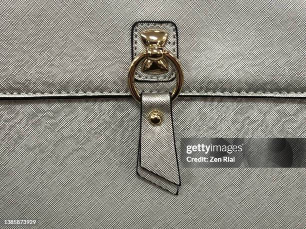 decorative details on flap of a gray lady's handbag - metallic purse photos et images de collection