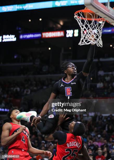 Reggie Jackson of the LA Clippers makes a basket over Chris Boucher of the Toronto Raptors in the second half at Crypto.com Arena on March 16, 2022...
