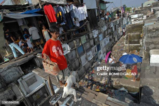 Squatter resident leaves their dwellings built on top of concrete tombs at the Navotas town public cemetery in suburban Manila, 01 November 2006...