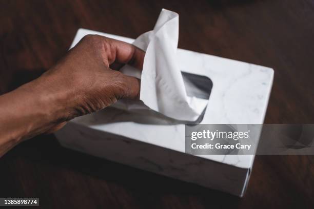 woman grabs a tissue from box - papiertaschentuch stock-fotos und bilder