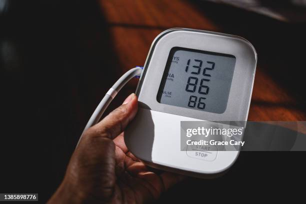 woman reviews a high blood pressure reading - high blood pressure stockfoto's en -beelden