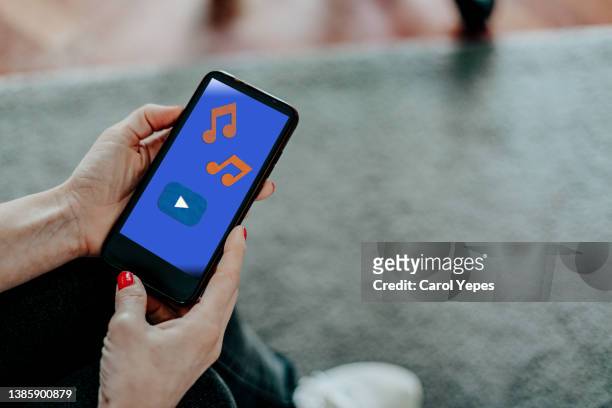 hand holding a smart phone that displays a music app - big tech foto e immagini stock