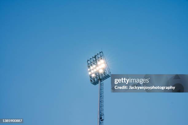 illuminated overhead stadium scene lights - reflector objeto fabricado fotografías e imágenes de stock