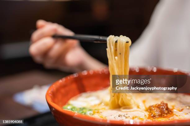 close-up of ramen noodles in red bowl on table - ramen noodles stock pictures, royalty-free photos & images