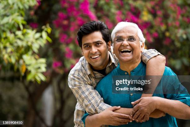 cheerful old man with son having fun at park - father son admiration stock pictures, royalty-free photos & images