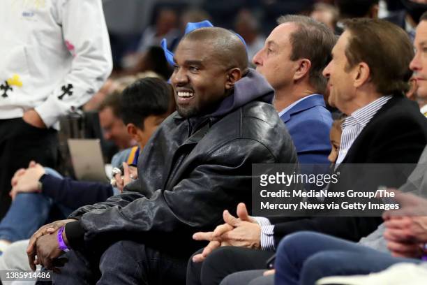 Kanye West, center, and his son, Saint West, got front row seats next to Golden State Warriors co-owners Joe Lacob and Peter Guber as they watch the...