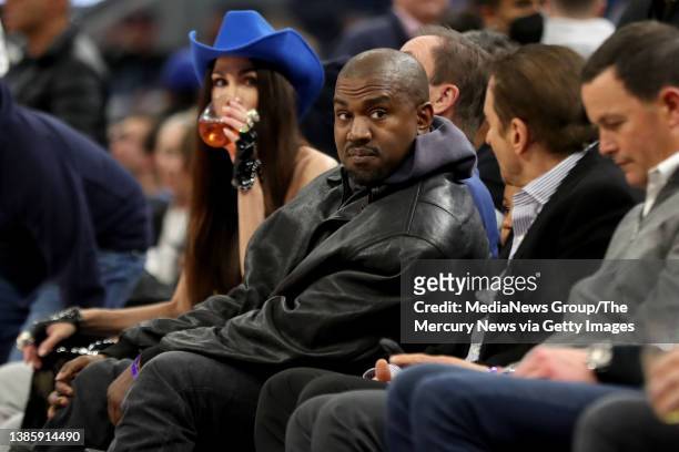 Kanye West, left, talks with Golden State Warriors co-owner Peter Guber the game during the game against the Boston Celtics in the third quarter at...