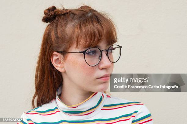 young woman with freckles and glasses looking away - woman portrait side stock-fotos und bilder
