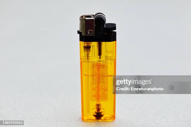 close up of yellow transparent lighter. - cigarette lighter stockfoto's en -beelden