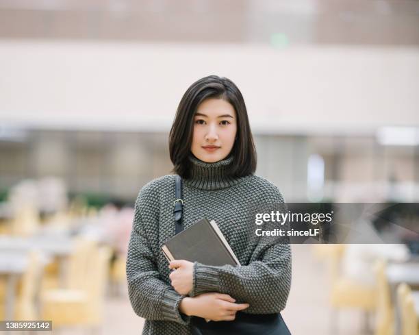 asian female students holding for selection book in library - students college beautiful bildbanksfoton och bilder