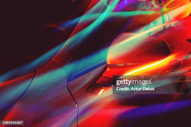 electric car part illuminated with colorful light trails flowing. - car reflection stock-fotos und bilder