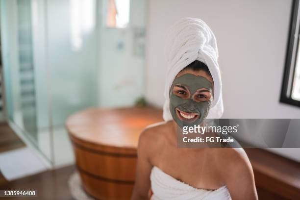 portrait of a mid adult woman with facial mask in the bathroom - fangoterapia imagens e fotografias de stock