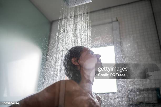 mujer tomando una ducha en casa - lavarse el cabello fotografías e imágenes de stock