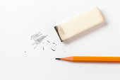 Eraser with traces of dust and a pencil on a white sheet