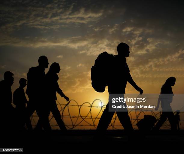 column of migrants walking to the border, immigration crisis - flüchtlingslager stock-fotos und bilder