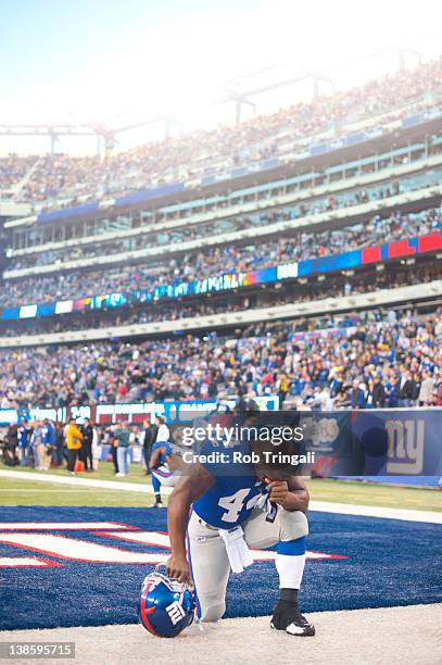 Running back Ahmad Bradshaw of the New York Giants kneels and prays before the game against the Green Bay Packers at MetLife Stadium on December 4,...