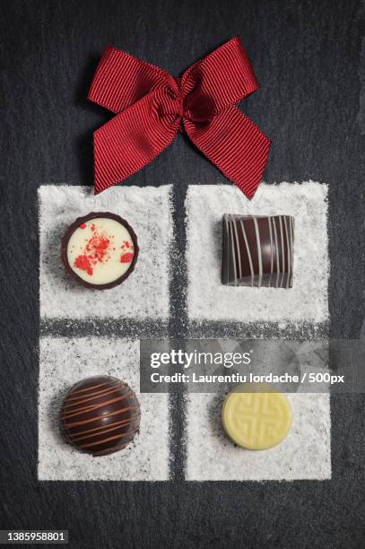 gift box chocolate pralines for christmas with chocolates and sugar powder and red bow - ardesia imagens e fotografias de stock