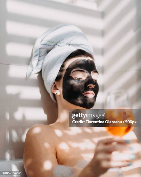 relaxing in the bathtub young woman in home spa with face mask,vienna,austria - kosmetikmaske stock-fotos und bilder