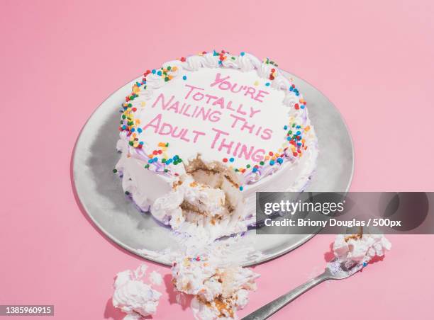 high angle view of cake with text against pink background - torto stock-fotos und bilder