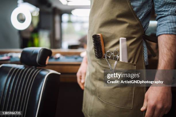 primer plano de un delantal de barbero irreconocible. - barbero peluquería fotografías e imágenes de stock