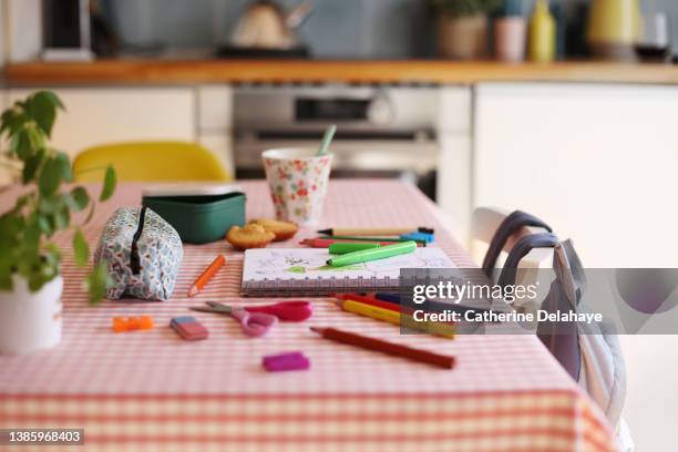 still life image of kindergarten work on a living room table having a snack - trousse d'écolier photos et images de collection