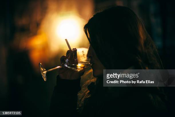 woman drinking white wine in the night - tobacco product stock photos et images de collection