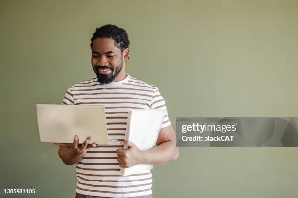portrait of african american man looking at the laptop - laptop coloured background stock pictures, royalty-free photos & images
