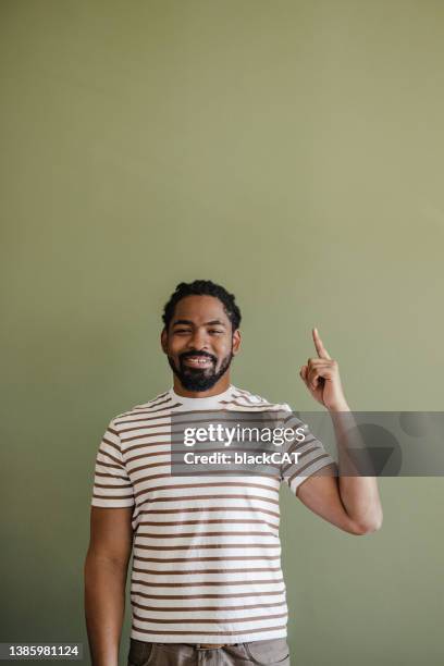studio shot of african american man with index finger up - hand opsteken stockfoto's en -beelden