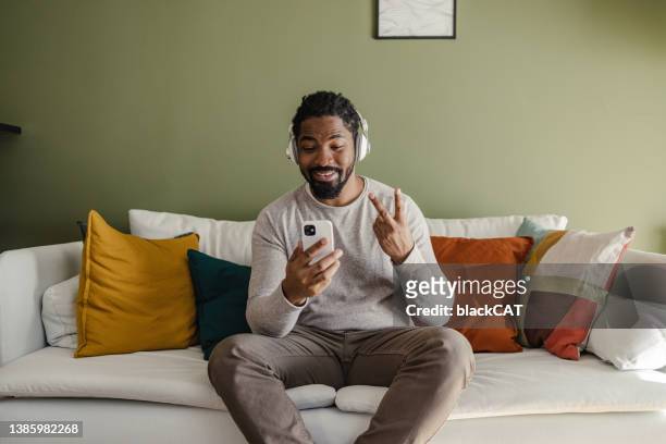young man at home, talking on a video call - two fingers stock pictures, royalty-free photos & images