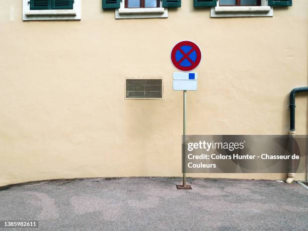 no parking sign on a sidewalk and in front of a wall in evian-les-bains - sidewalk sign stock pictures, royalty-free photos & images