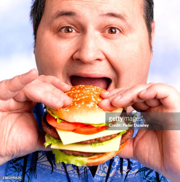overweight man eating burger - obesity concept stock pictures, royalty-free photos & images