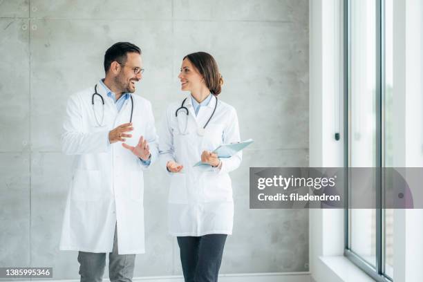 dos trabajadores de la salud hablando en el hospital - bata de laboratorio fotografías e imágenes de stock