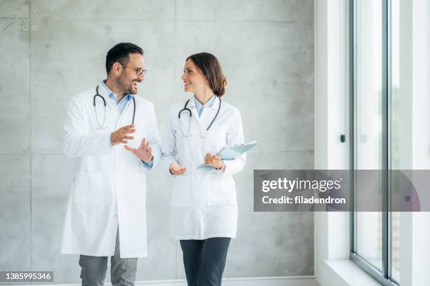 dois profissionais de saúde conversando no hospital - duas pessoas - fotografias e filmes do acervo