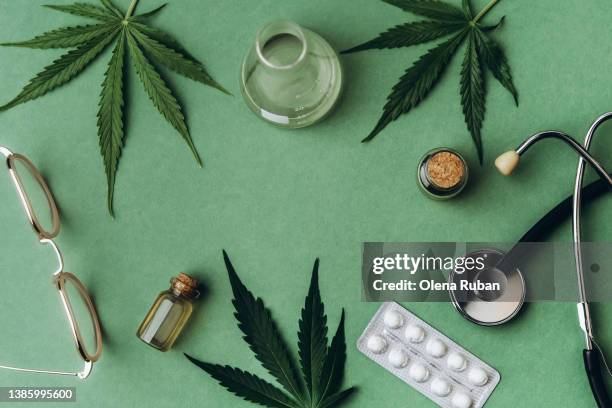 cannabis leaves, flask, pills, stethoscope, cbd oil, eyeglasses. - medizinalhanf stock-fotos und bilder