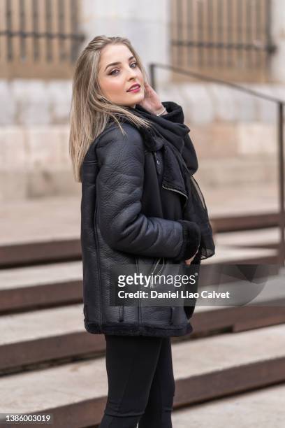 stylish woman in a warm black leather jacket posing outdoors on the street. - latina glamour models - fotografias e filmes do acervo